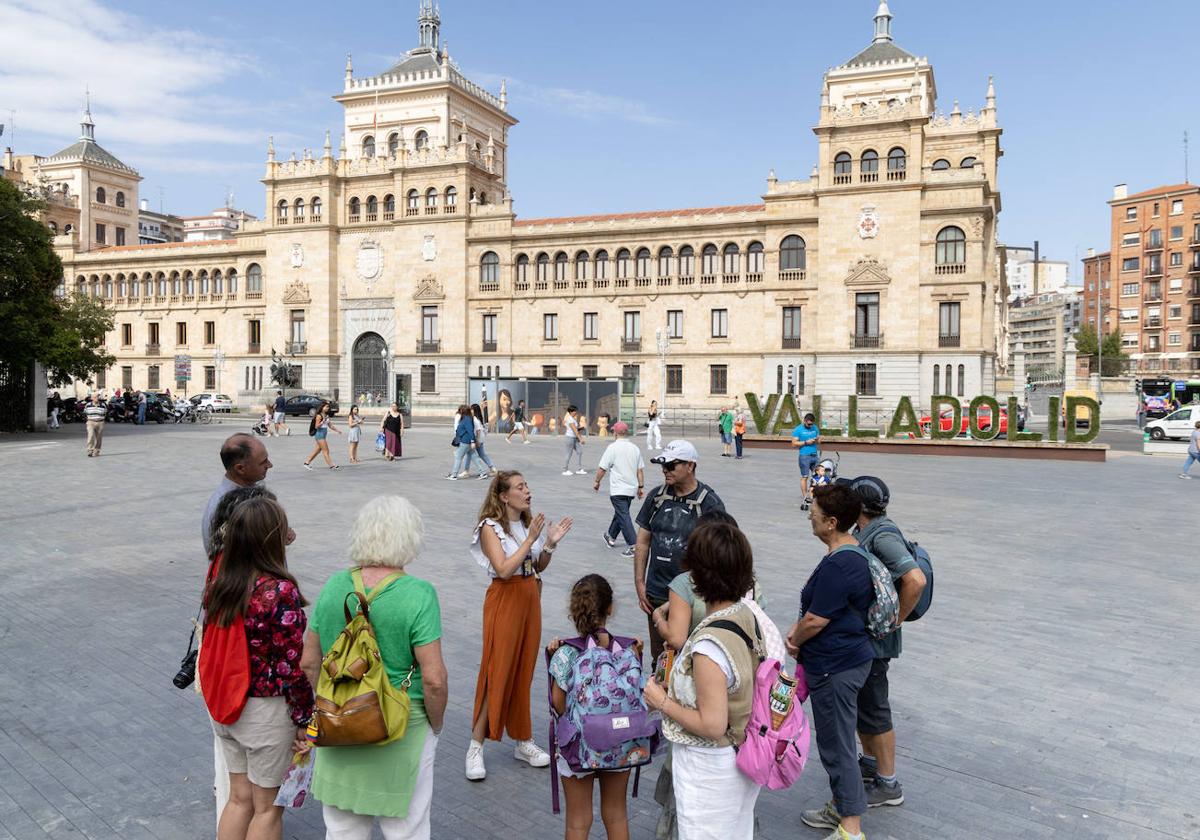 Un grupo de turistas atiende las explicaciones de una guía turística en Valladolid.