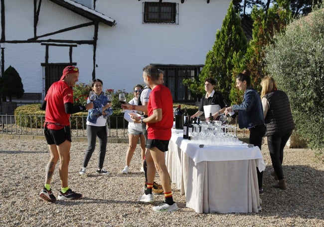 Corredores haciendo una parada y disfrutando de una copa de vino en una de las bodegas participantes.