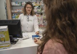 Una mujer compra un test de antígenos en una farmacia de Segovia.