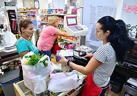 Desi Asenova atiende a varios clientes en su tienda de alimentación de productos búlgaros