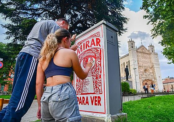 Marina Carvajal (Valladolid, 2002) y Román Olmos Horbunov (Sambir, Ucrania, 2001) decoran un cuadro eléctrico situado entre la calzada y un jardín de la plaza de San Pablo.