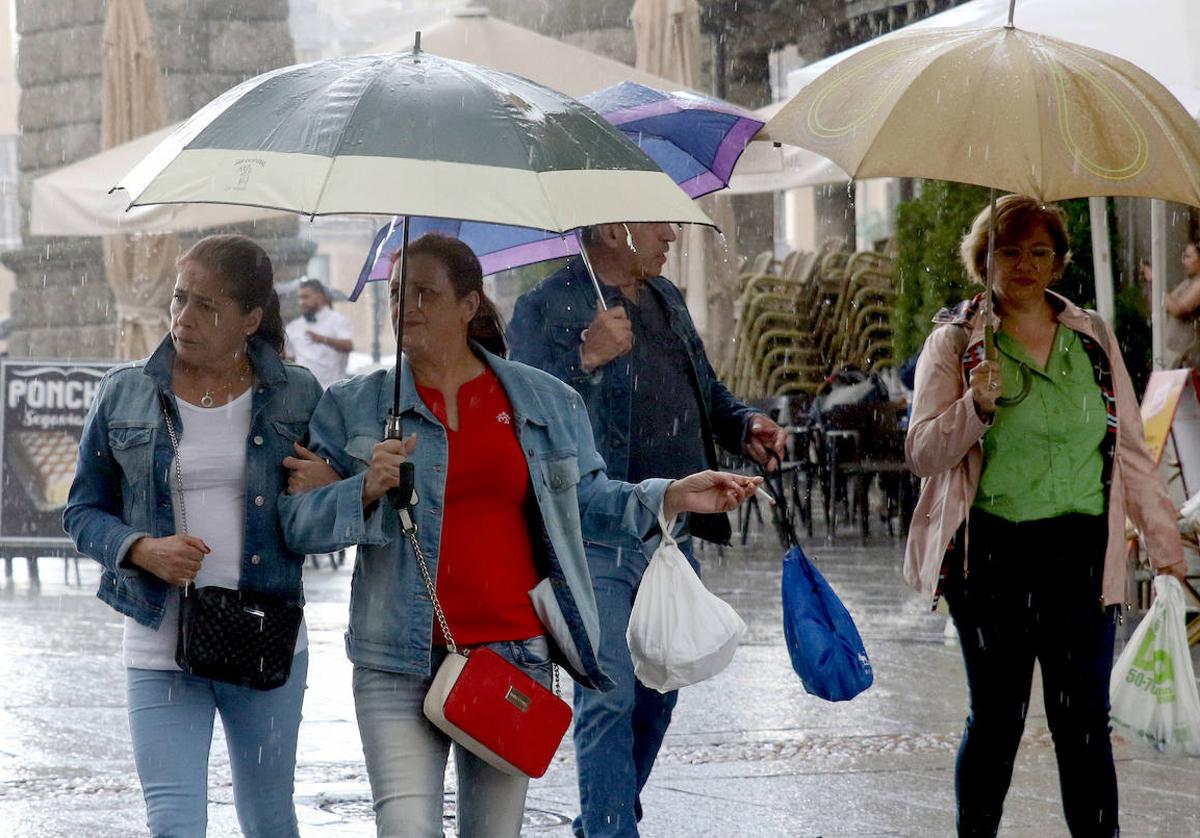 Varias personas pasean abrigadas bajo la lluvia por la ciudad de Segovia esta semana.