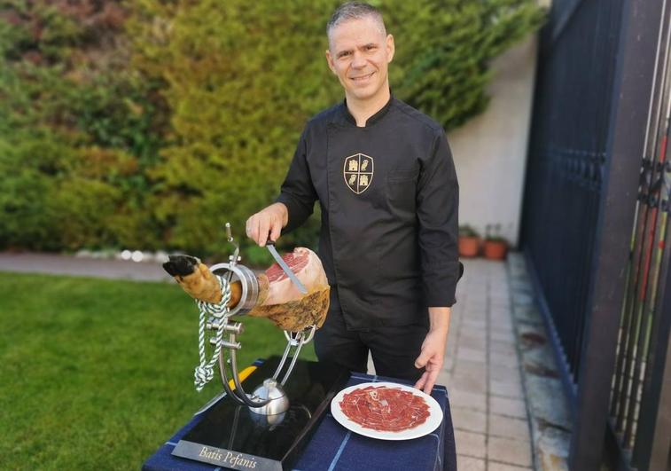 El cortador profesional de jamón, el griego Batis Pefanis, con el jamonero que lleva su nombre