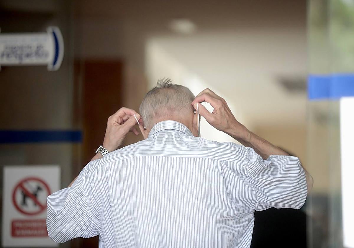 Un hombre se coloca la mascarilla para entrar a un centro de salud de Valladolid.