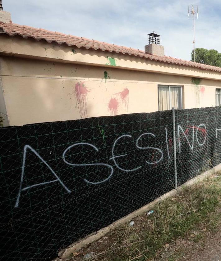 Imagen secundaria 2 - En la entrada de la parcela, un cartel advierte de las cámaras y otro responde. Bajo estas líneas, más pintadas con insultos en las vallas que rodean la finca.