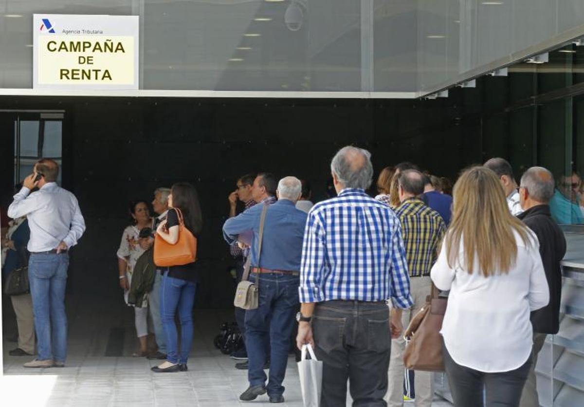 Contribuyentes hacen cola a la puerta de la delegación de la Agencia Tributaria para recibir ayuda con su declaración de la Renta.