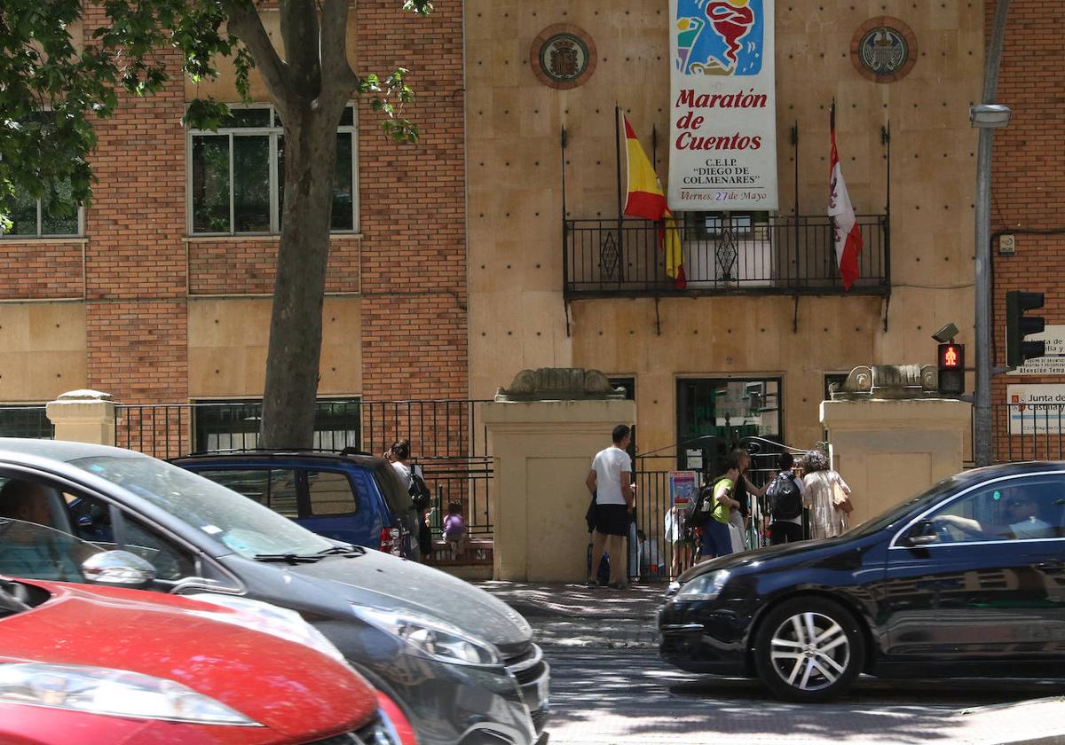 Tres coches pasan frente a la puerta del colegio Diego de Colmenares.