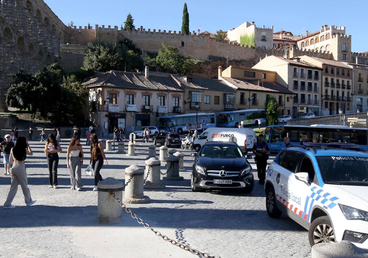 Varias personas pasean por la plaza Oriental en un momento de tráfico denso.