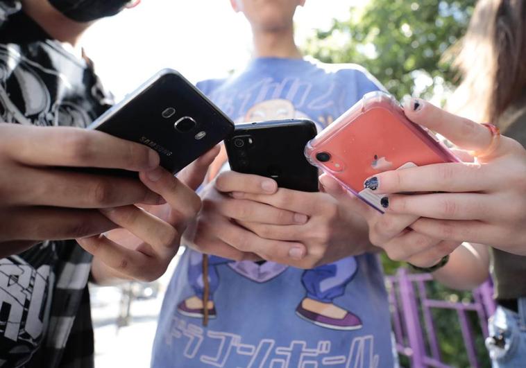 Varios jóvenes utilizan sus teléfonos móviles, en una imagen de archivo.