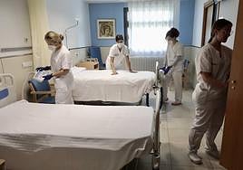 Personal del Hospital Benito Menni prepara una habitación en la Unidad de Cuidados Paliativos.