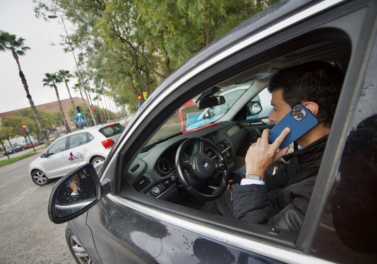 Un conductor habla por el teléfono móvil.