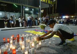 Un hombre coloca velas en recuerdo de los fallecidos en el incendio de las discotecas de Murcia.