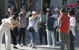 Turistas asiáticos realizan fotografías en una visita a la ciudad de Segovia.