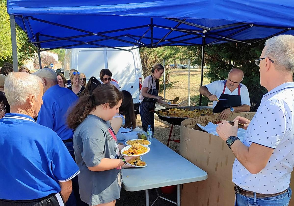 Participantes en la jornada recogiendo su ración de paella.