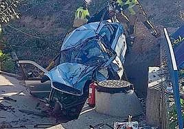 Los bomberos tratan de sacar al herido del interior del coche siniestrado.