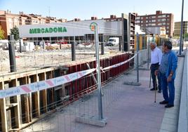 Dos vecinos observan el avance de las obras del nuevo supermercado de Arca Real, que abrirá el 6 de noviembre.