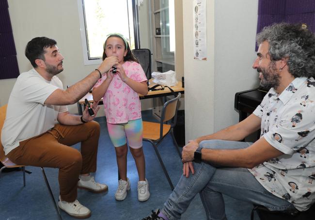 Mafalda Aragón, ayudada por su profesor de clarinete en presencia de su padre.