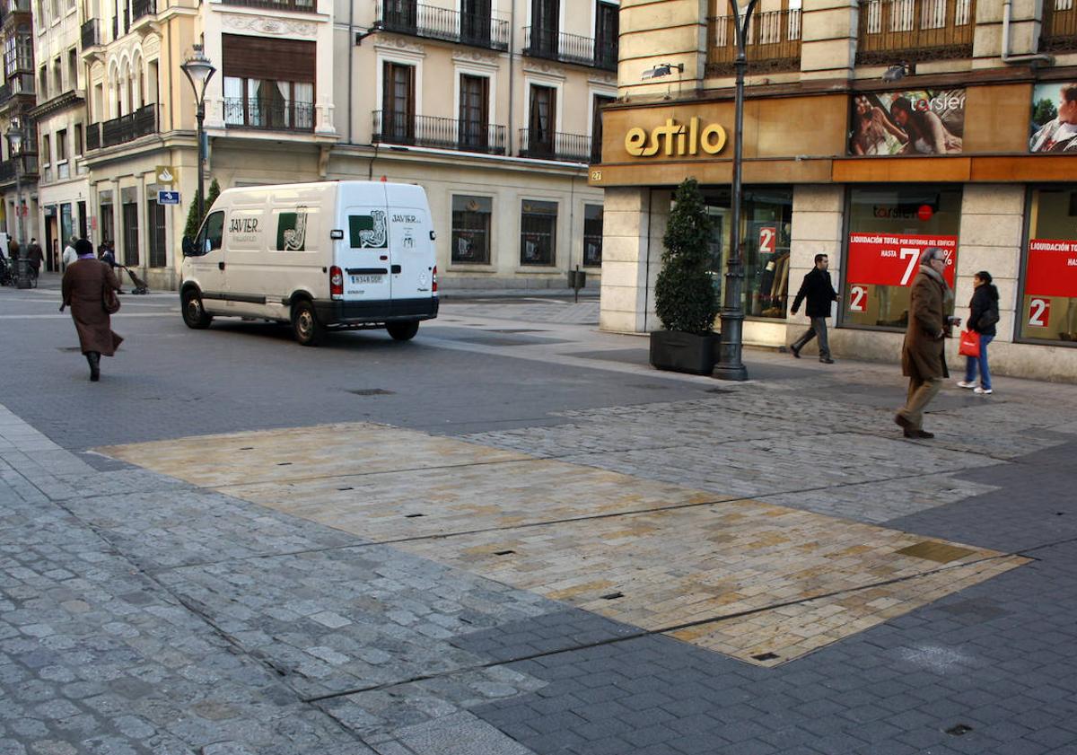 Imagen principal - Arriba, adoquinado que marca la presencia del puente del Esgueva en la calle Santiago. Debajo, a la izquierda, interior del puente de la Puerta del Campo y (derecha) el ojo al descubierto del mismo.