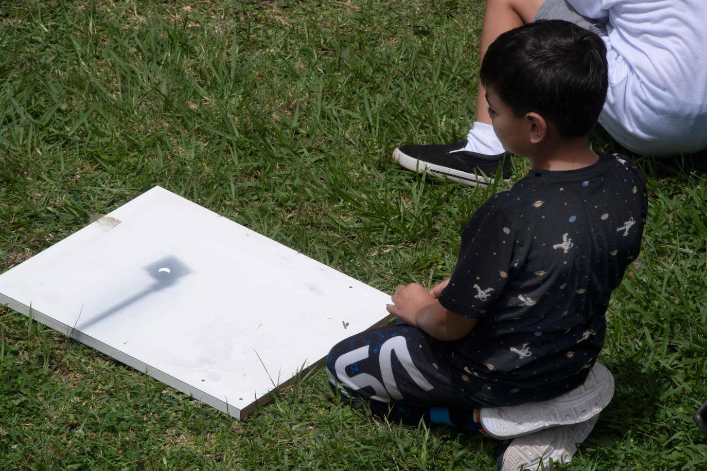 Un niño observa una imagen proyectada del elcipse solar desde una universidad de Costa Rica