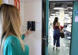 Una trabajadora ficha a la entrada a su trabajo.