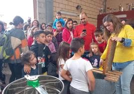 Los niños atienden la explicaciones de Ana Olmo en el taller de extracción de la miel.