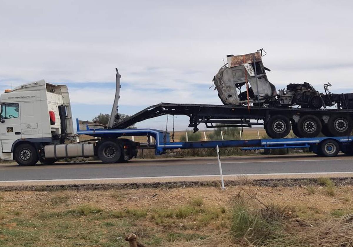 Un camión transporta uno de los vehículos que ardieron en la carretera A-6.