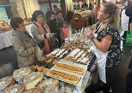 Una mujer atiende a los visitantes en uno de los puestos de la feria.