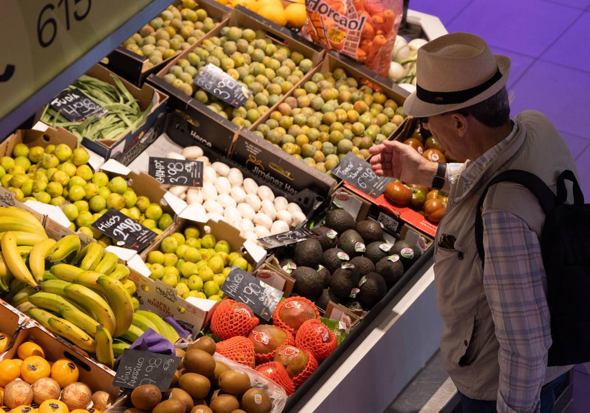 Un hombre, en la frutería de un mercado municipal.