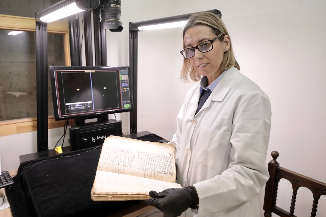 Esperanza Luque, técnica de archivo, con uno de los documentos listos para su digitalización.