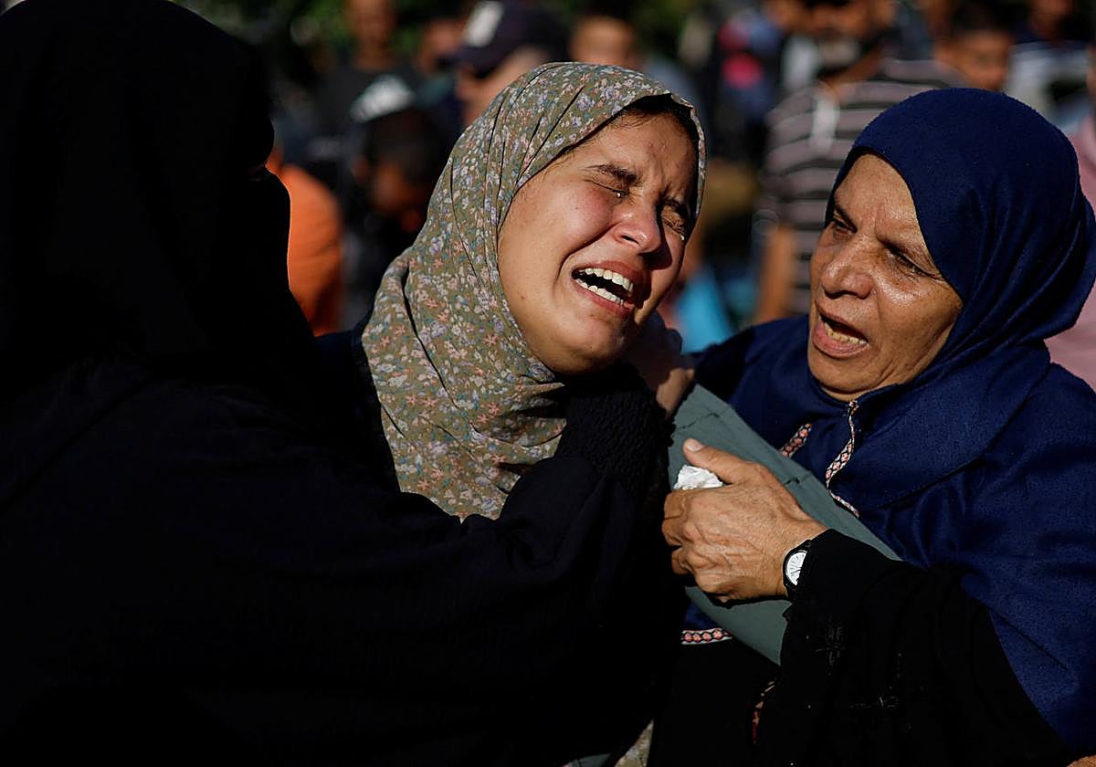 Dos mujeres lloran durante un funeral por los palestinos asesinados por ataques israelíes.
