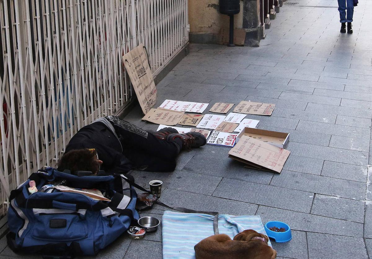 Una persona sin hogar, junto a su perro, en una de las calles de Segovia.