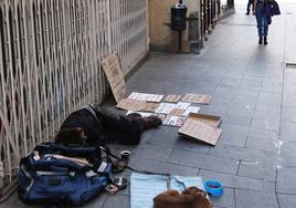 Una persona sin hogar, junto a su perro, en una de las calles de Segovia.