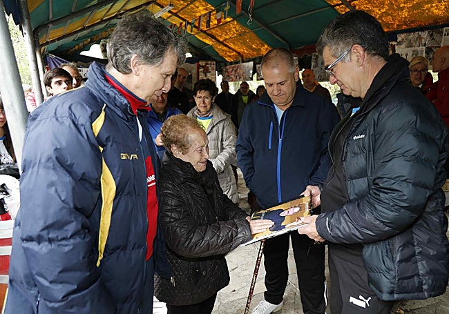 La viuda de Jesús Gómez recibe, emocionada, de parte de exjugadores del Deportes Gómez, un libro de fotografías de su marido.