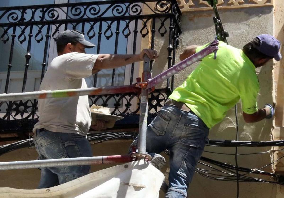 Dos hombres trabajan en la rehabilitación de un edificio en Segovia.