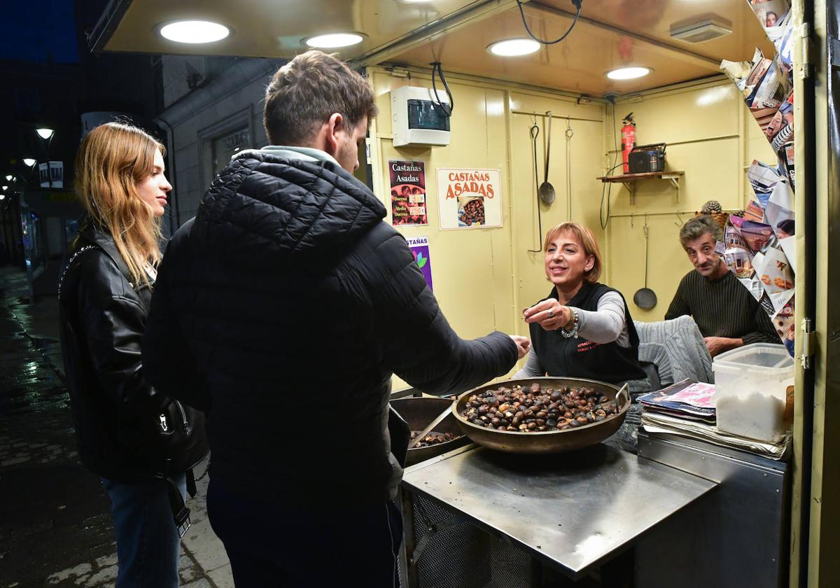 Begoña sirve un cucurucho de castañas, en la calle Constitución.