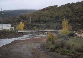 Pasarela que será demolida y caudal del río Carrión a su paso por Velilla.