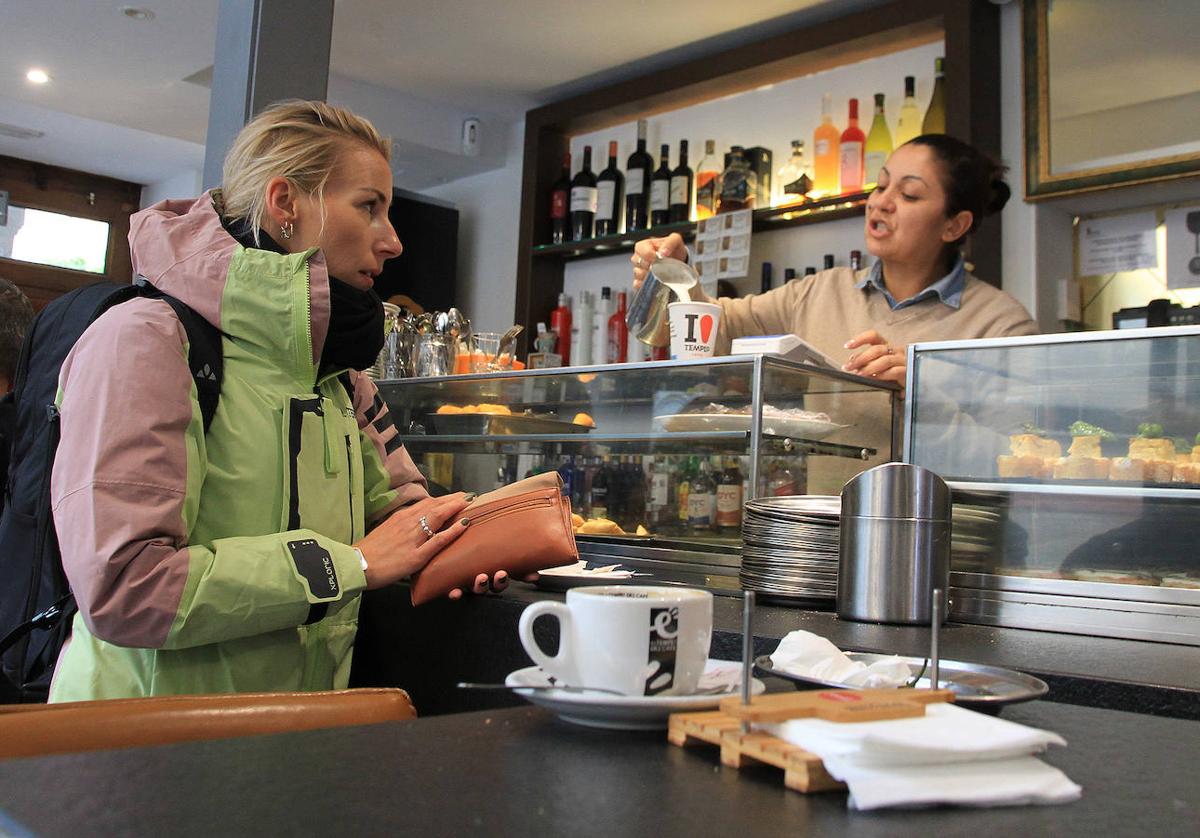 Una trabajadora hostelera sirve un café.