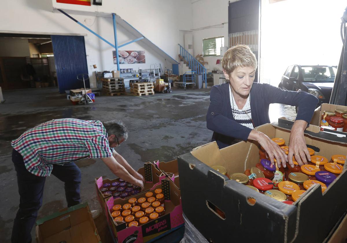 La secretaria del Banco de Alimentos, Rosa Ortega, reparte unos botes entre los pedidos.