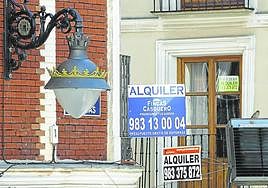 Carteles que anuncian pisos y oficinas en alquiler en Valladolid.