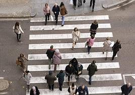 Varias personas cruzan el paso de peatones de la calle San Ildefonso.