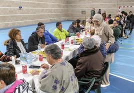 Una mujer abraza a una vecina en una comida de hermandad para agradecer el apoyo recibido.