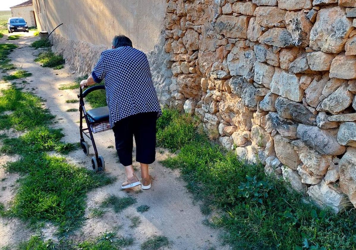 Una vecina pasea con su andador por una de las calles de Tanarro.