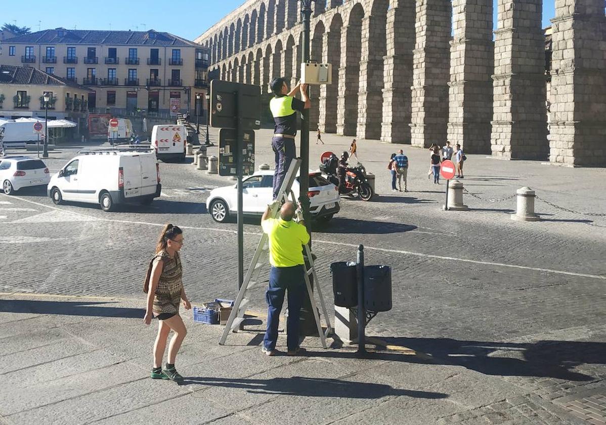 Operarios colocan un aforador para medir el tráfico.