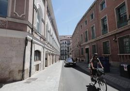 Un ciclista y un vehículo circulan por la calle Leopoldo Cano junto al Teatro Calderón.
