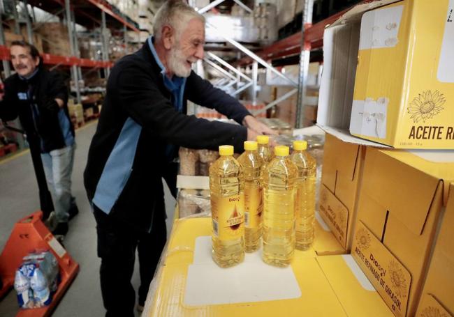 Un voluntario coloca botellas de aceite.