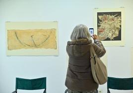 Una visitante fotografía el grabado por el que pujará.