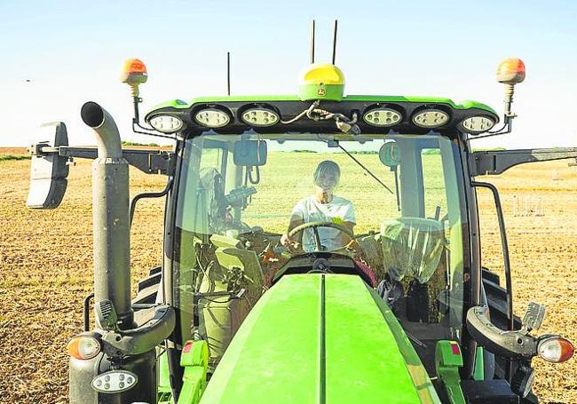 Una agricultora, al volante de su tractor.