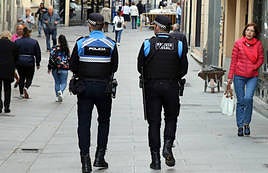 Dos agentes de la Policía Local patrullan a pie por una calle de Segovia.