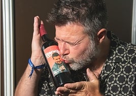 Héctor de Miguel besa una botella etiquetada con su imagen.