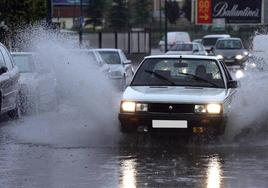 Un coche se abre paso durante una tromba de agua en Valladolid.